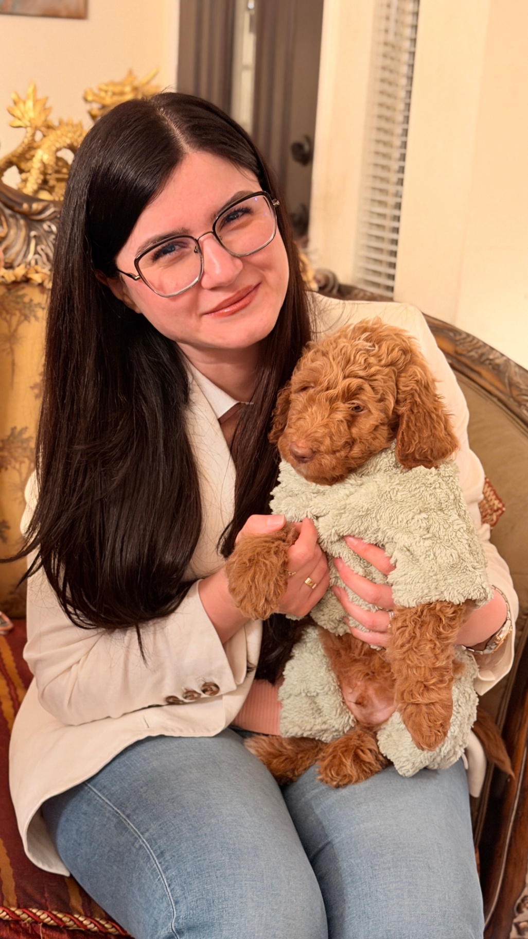 A Kid's Best Doodle owner holding her Goldendoodle puppy at home