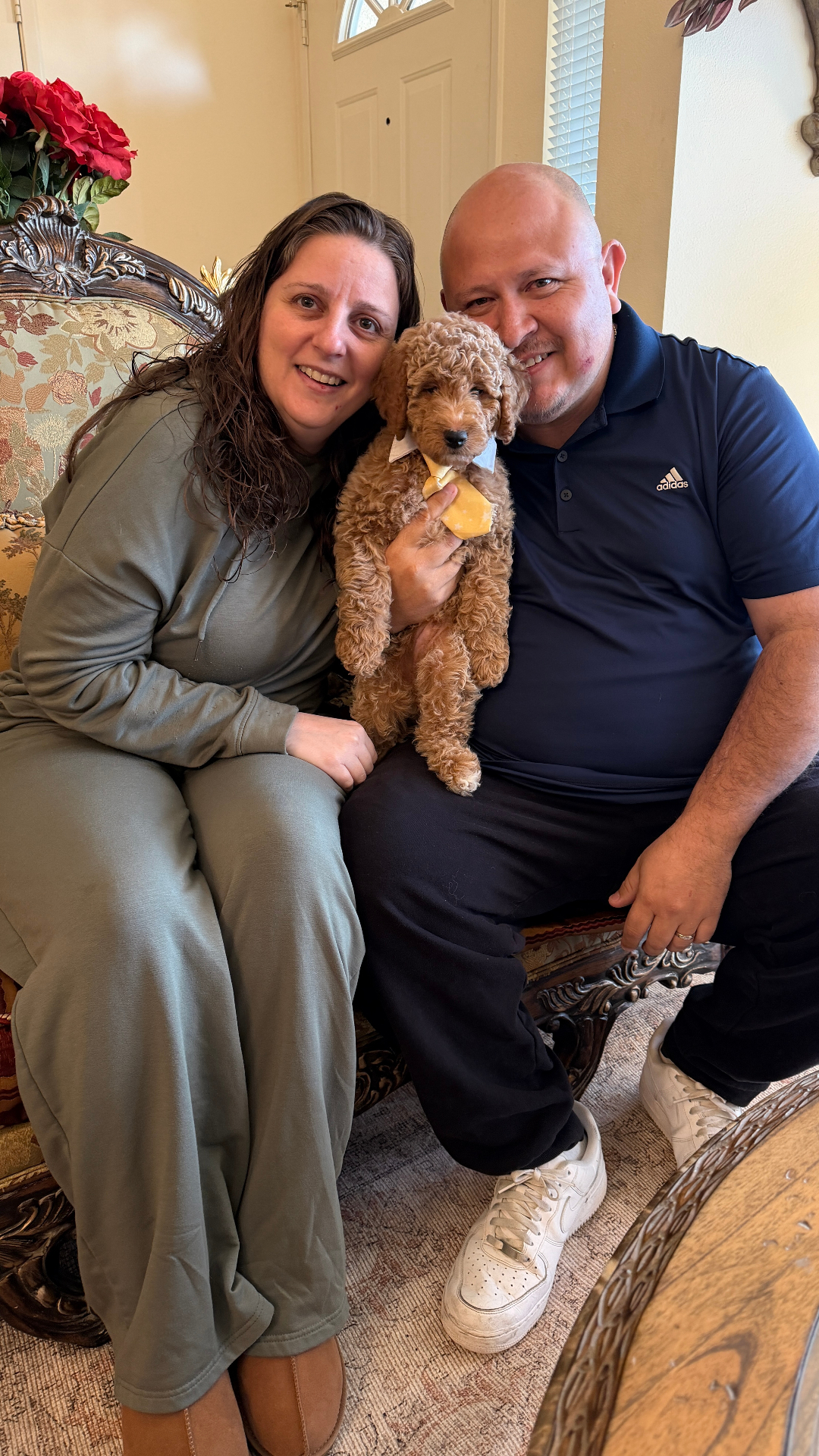 A family sitting together with their Kid's Best Doodle puppy at homecoming